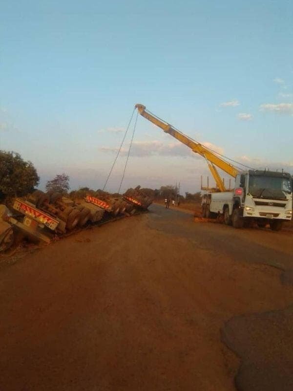 911 recovery crew rigging an overturned truck for recovery
